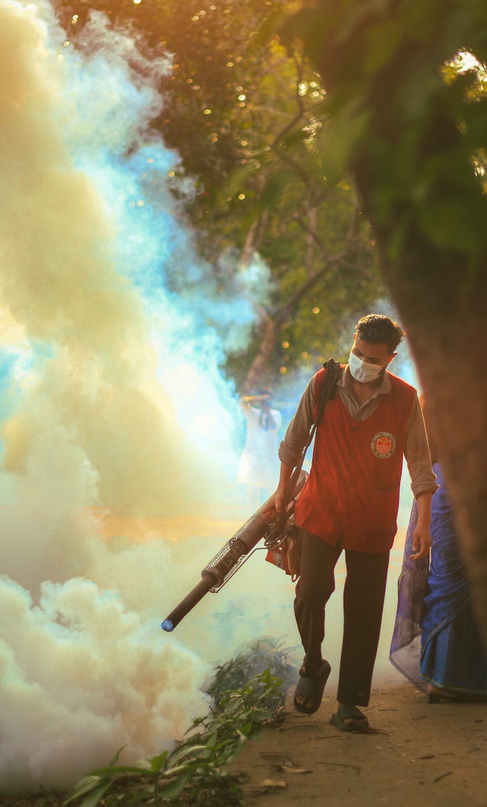 home-hero A worker performs fogging to control mosquitoes in a city park during the afternoon.