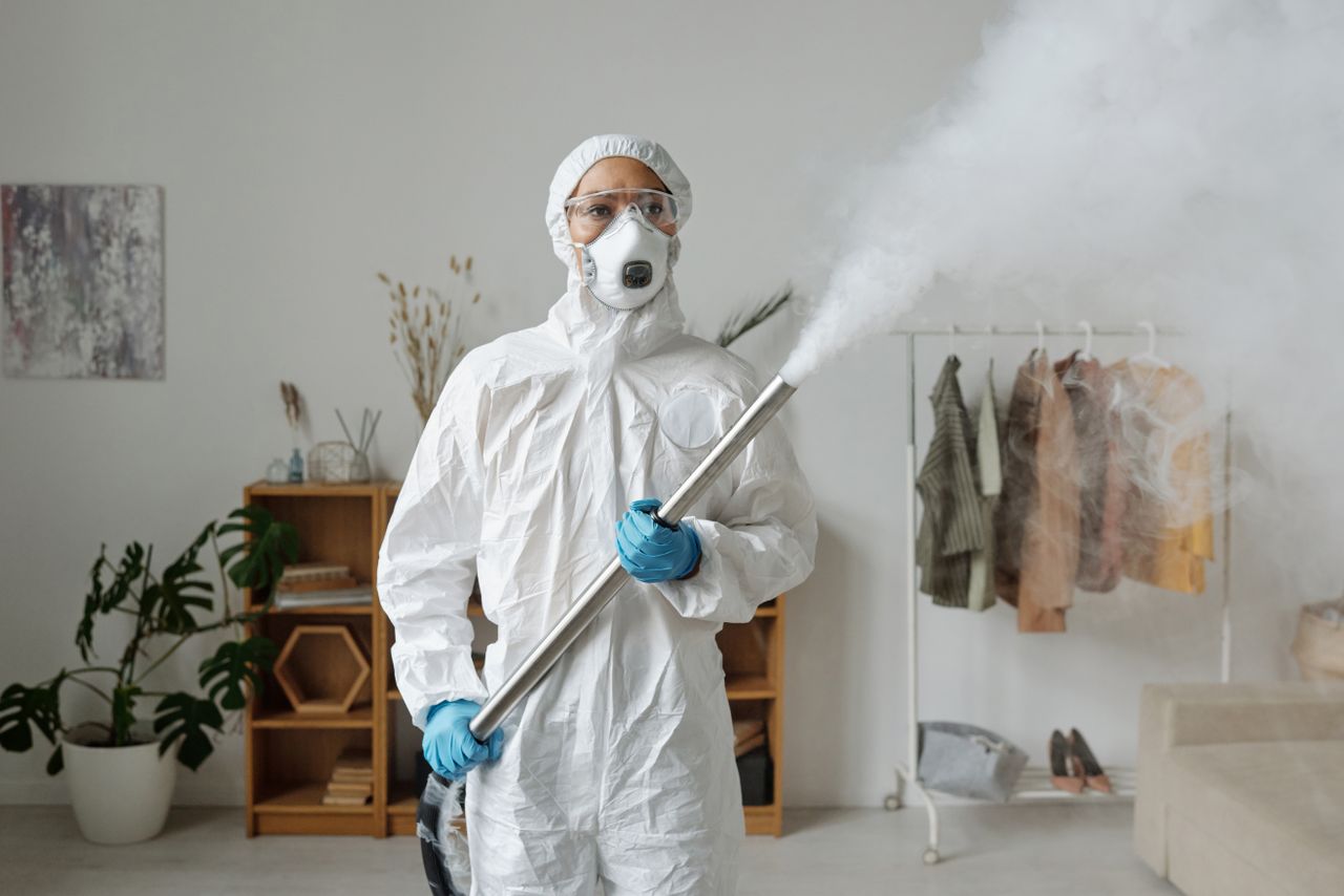 services-01 A person in full protective gear fumigates indoors for sanitization.